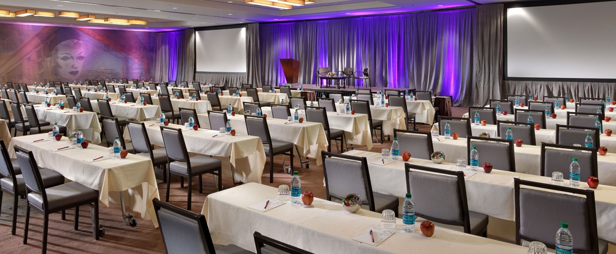 Corporate meeting with attendees seated at round tables in a conference room