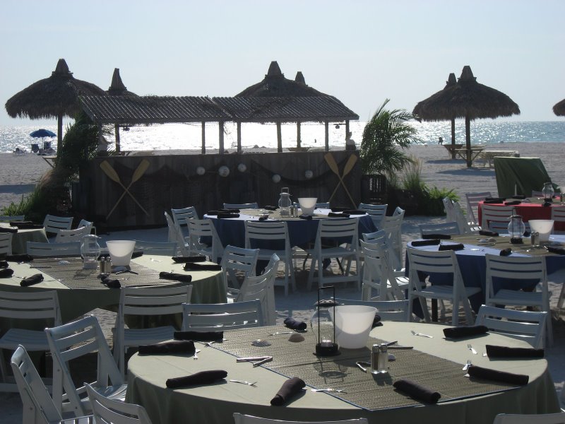 Outdoor beach event setup with tables and chairs for an incentive travel program
